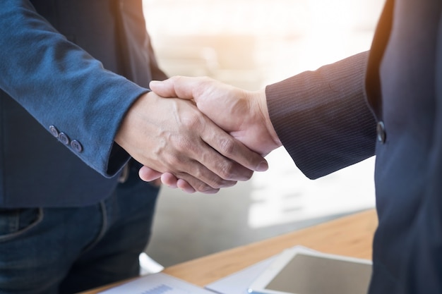 Foto grátis dois homens de negócios confiantes apertando as mãos durante uma reunião no escritório, sucesso, trato, saudação e conceito de parceiro